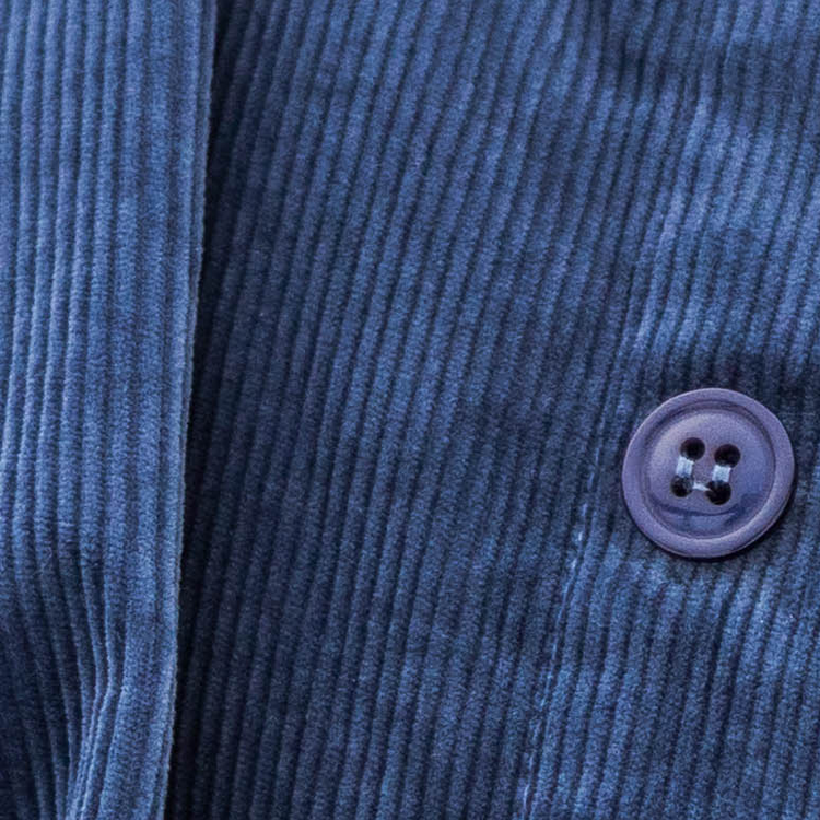 Close-up of a blue corduroy jacket with a button